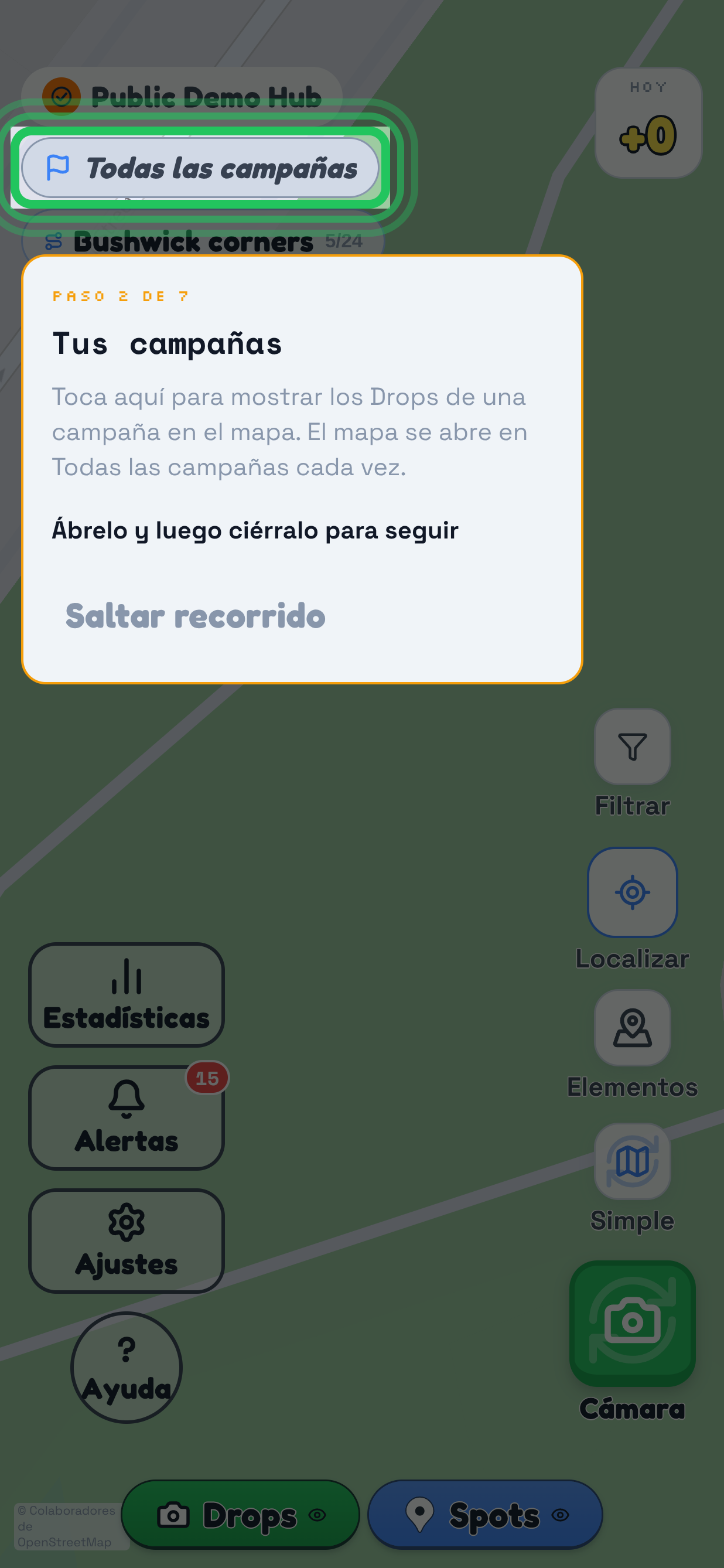 Una guía interactiva que se reproduce sobre el mapa en TraceReach Drop, toda la pantalla oscurecida. Marcado en ella: la píldora de campaña que dice Community Wave 1, que lleva el propio anillo de la guía. La tarjeta debajo dice Paso 2 de 7, Tus campañas, luego Toca aquí para elegir la campaña que coincide con los materiales que llevas, luego Ábrela y ciérrala para continuar, y Saltar tour.