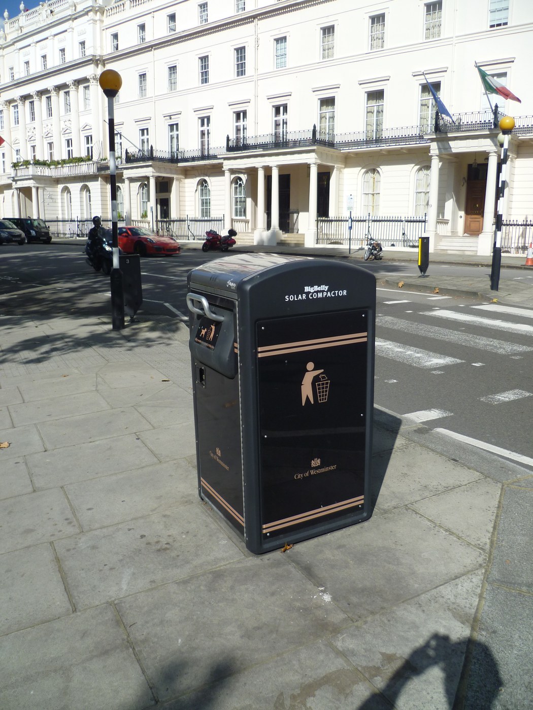 BigBelly solar compactor on a Belgrave Square pavement with a large blank front panel, Georgian terrace and street in the background.