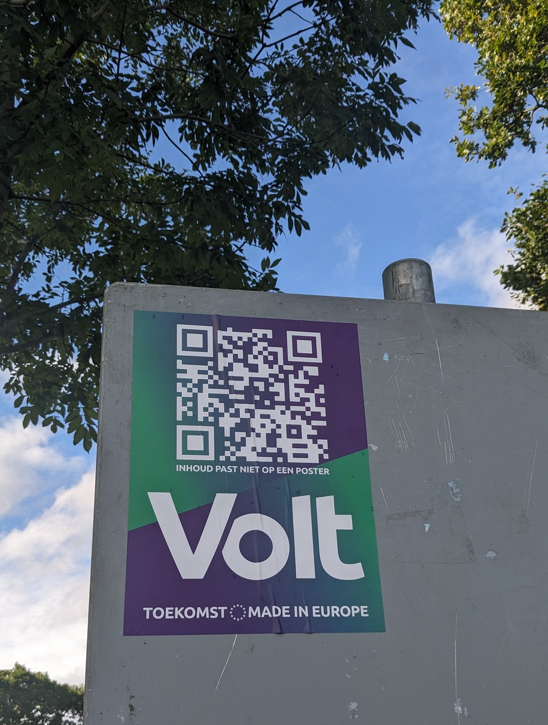 Election poster on a concrete billboard pillar with a large QR code above the party name.